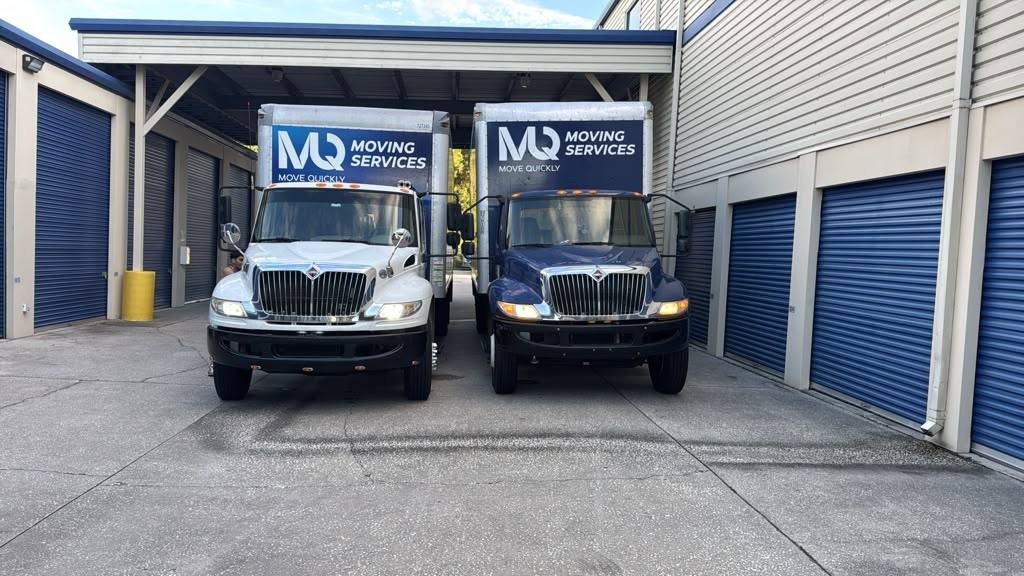 Two Move Quickly LLC branded moving trucks at a Tampa Bay storage facility — licensed and insured Florida movers